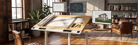 VersaDesk bamboo drafting table with architectural blueprints, rolled drawings and drafting tools, 3D house render on monitor in warm brick loft studio with leather chair and bookshelf