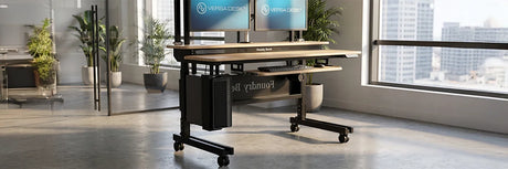 VersaDesk standing desk frame with dual-motor legs and reinforced crossbar demonstrating superior stability in modern office