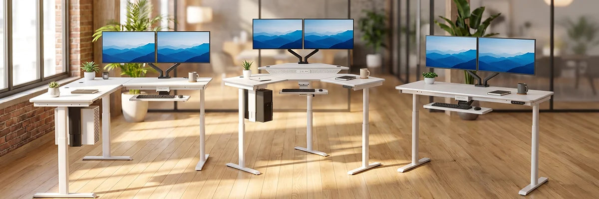 Three white VersaDesk standing desks displayed side by side showing L-shaped, corner and straight configurations with dual monitors in bright office