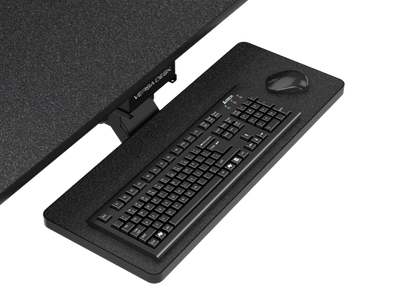 Black under-desk keyboard tray extended from a VersaDesk workstation, holding a keyboard and wireless mouse.